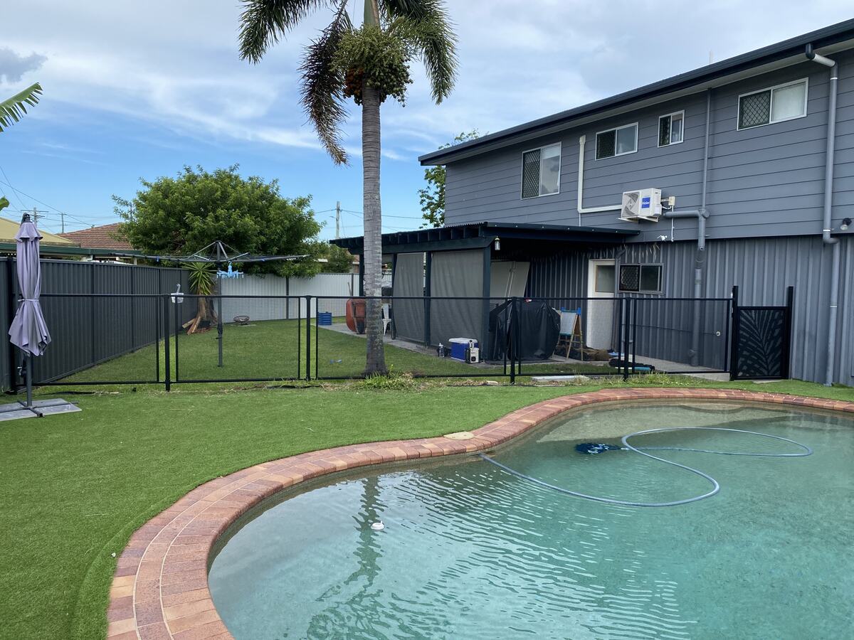 Pure Perf pool fencing around a kidney pool with palm tree, Queensland