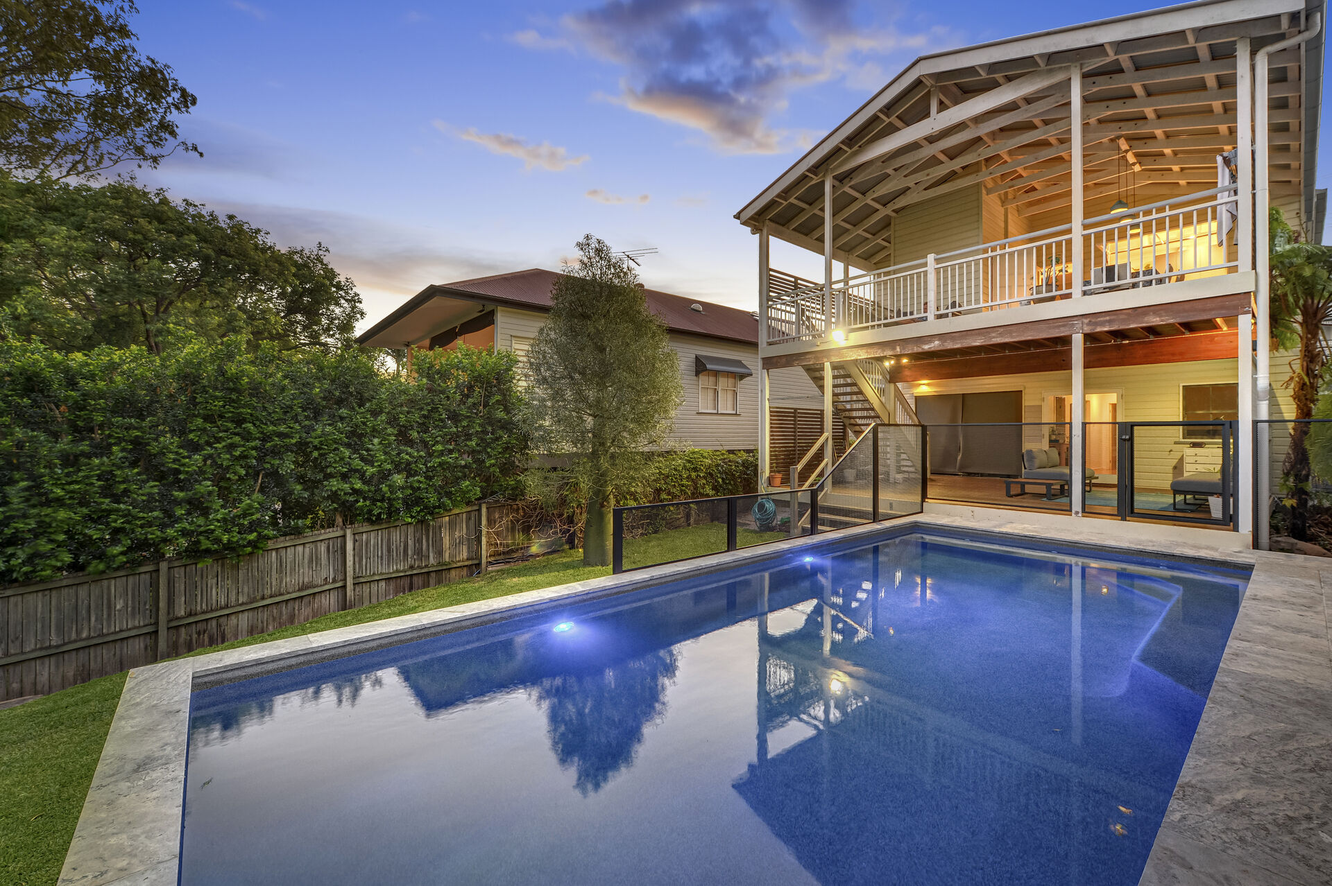 Pure Perf pool fencing in Textured Black around a pool at twilight beside a Queenslander home